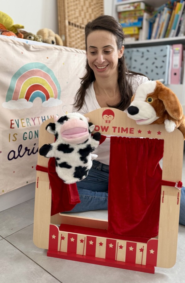מעיין משחקת עם בובות יד בתיאטרון בובות בחדר הטיפולים